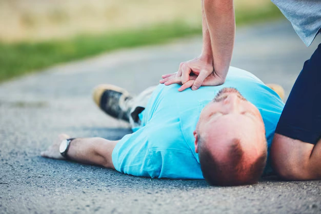 Bystander performing CPR on an unconscious accident victim, illustrating the severity of injuries in emergency situations.