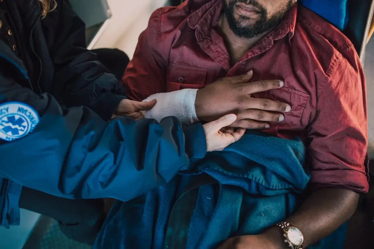 Injured man receiving emergency medical care for an arm injury, highlighting the importance of seeking treatment after an accident.