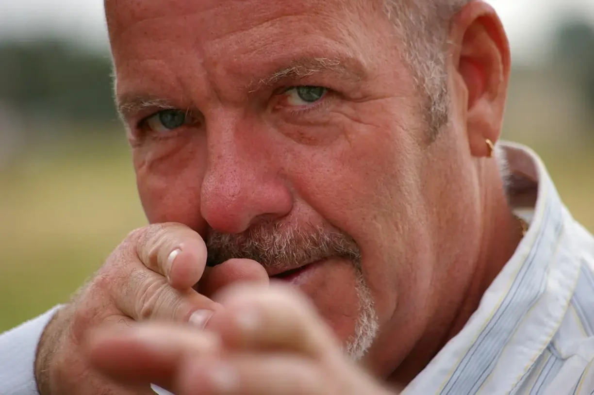 Aggressive man pointing directly at the camera, symbolising intimidation, harassment, and threatening behaviour.