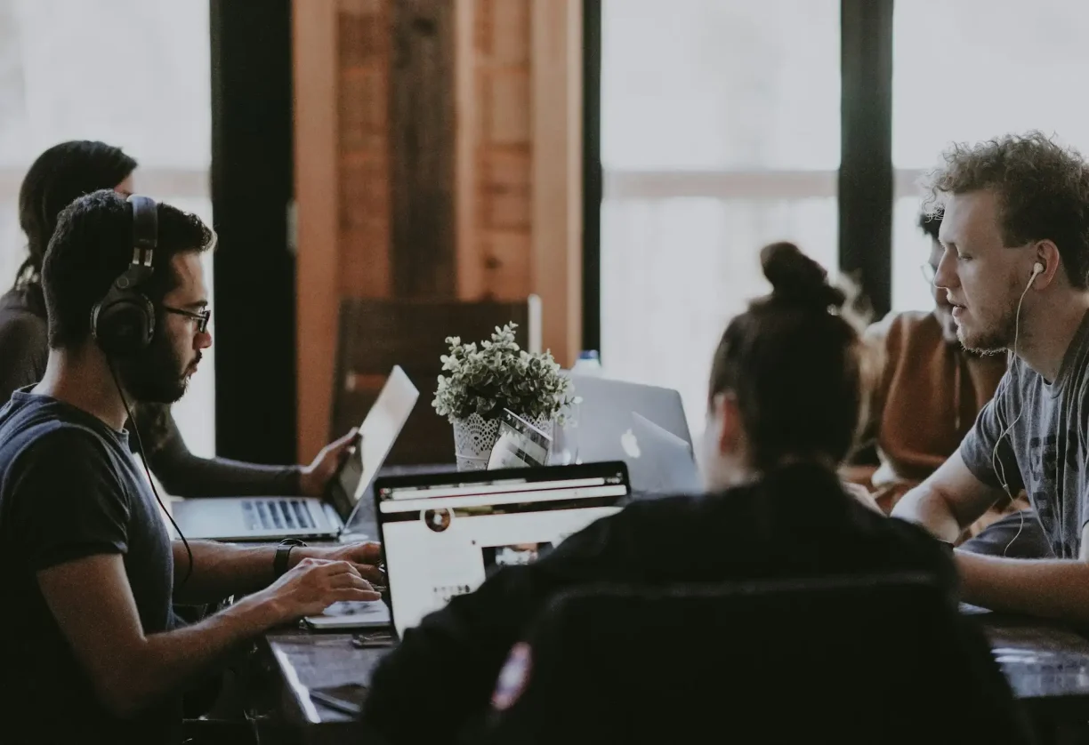 Employees collaborating in a modern workplace discussing job responsibilities and pay concerns