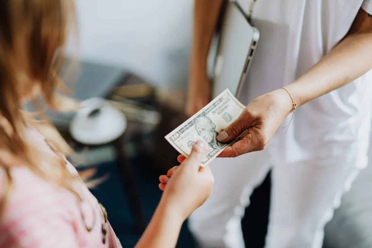 Worker receiving cash payment highlighting potential off the books wage issues