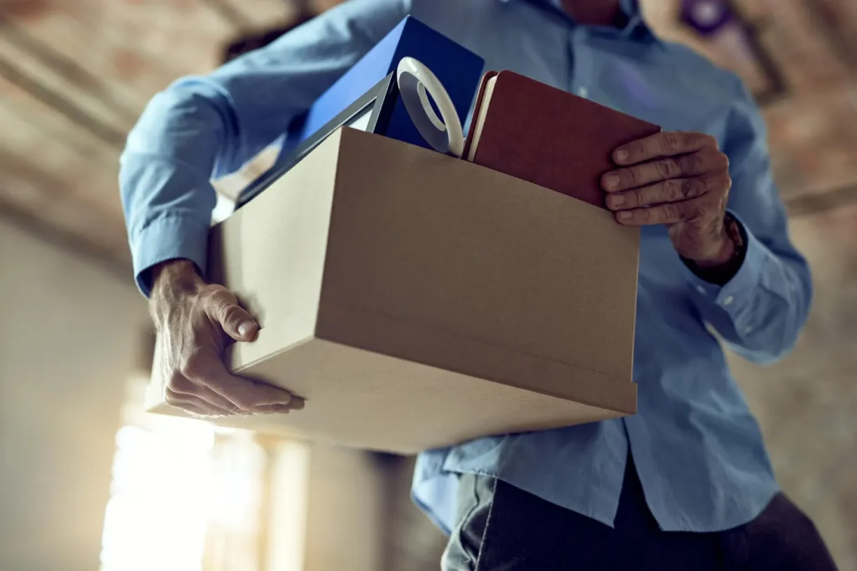 Wrongfully terminated worker holding belongings and reviewing how to file for wrongful termination