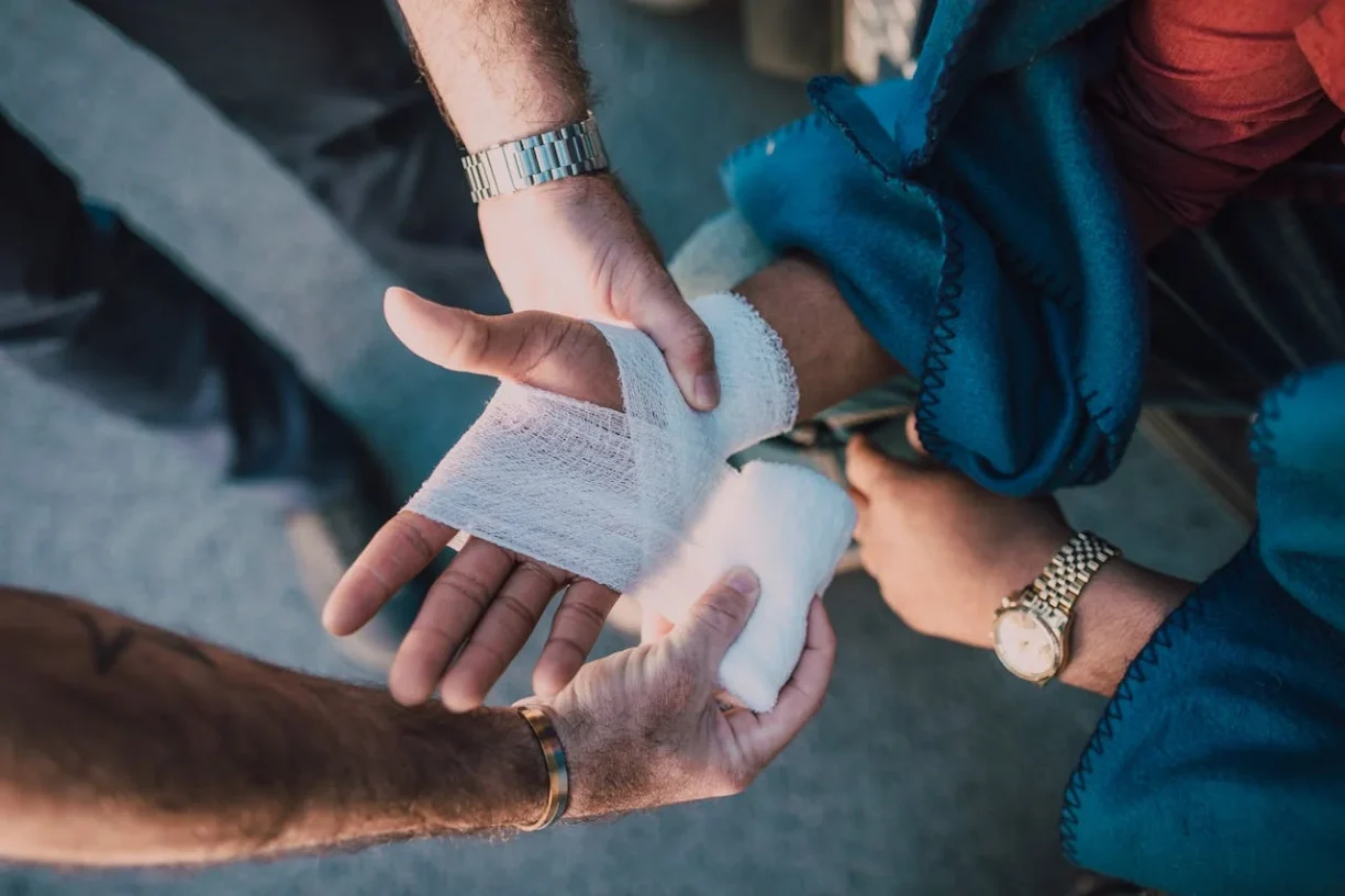 Close-up of medical gauze being applied to an injured hand, illustrating the physical recovery process before hiring a personal injury lawyer for a claim.