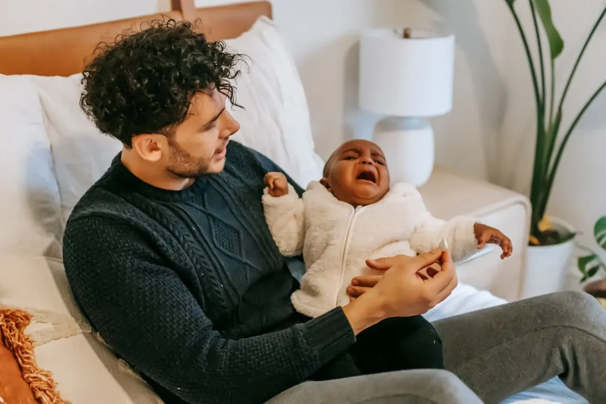 Father navigating california paternity leave laws while caring for newborn at home